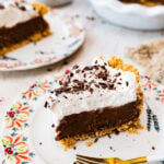 slice of pie on a plate with pretty flower designed edges. Fork on plate.