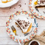 slices of pie on a plates with pretty flower designed edges. Fork on plate.