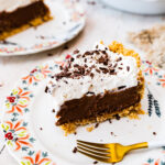 Slice of chocolate pudding pie on a plate with a fork.