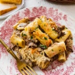 Leftover pot roast casserole and a fork on a red and white plate.