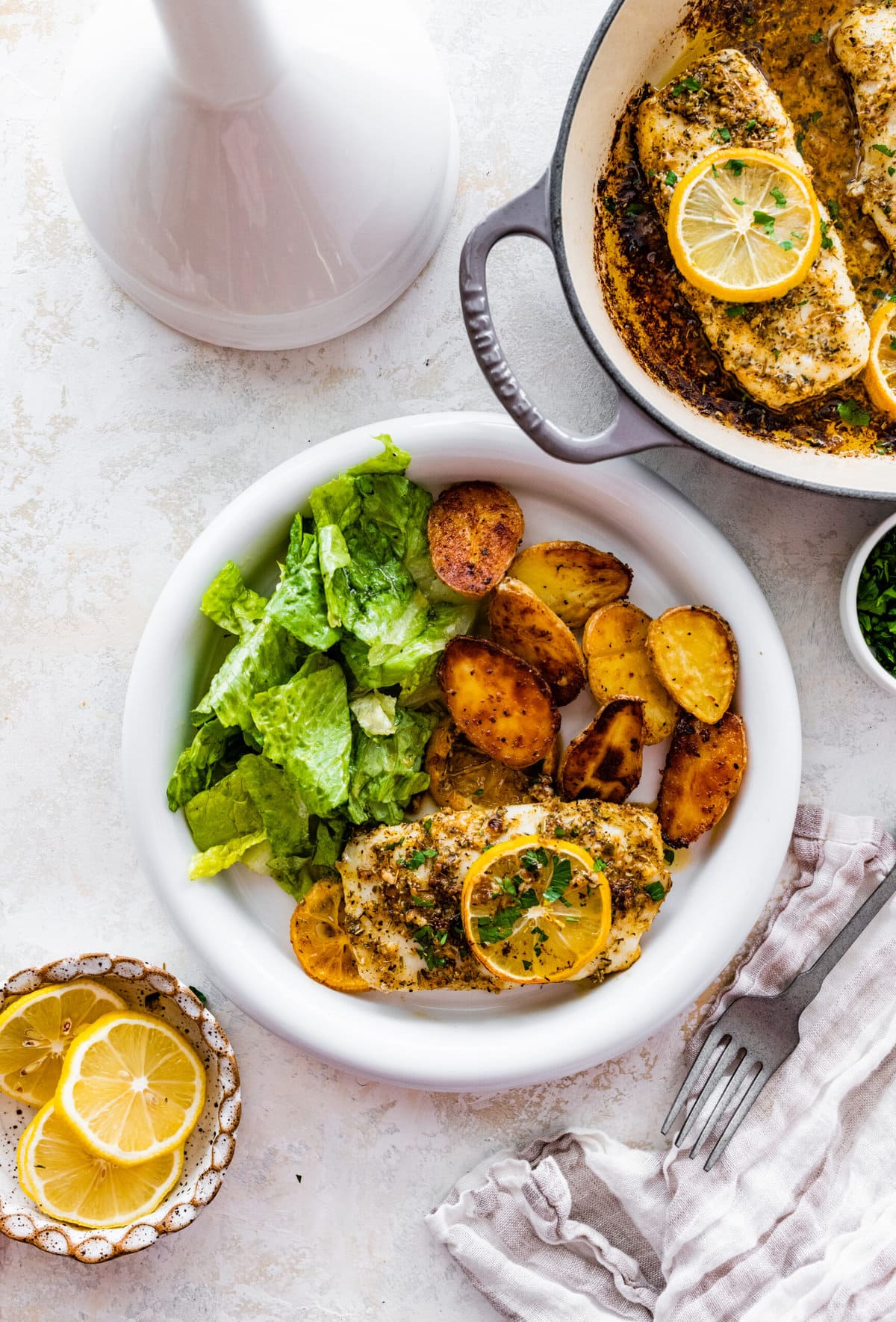 plated cod with oven baked potatoes and green salad.