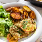 plated cod with oven baked potatoes and green salad.