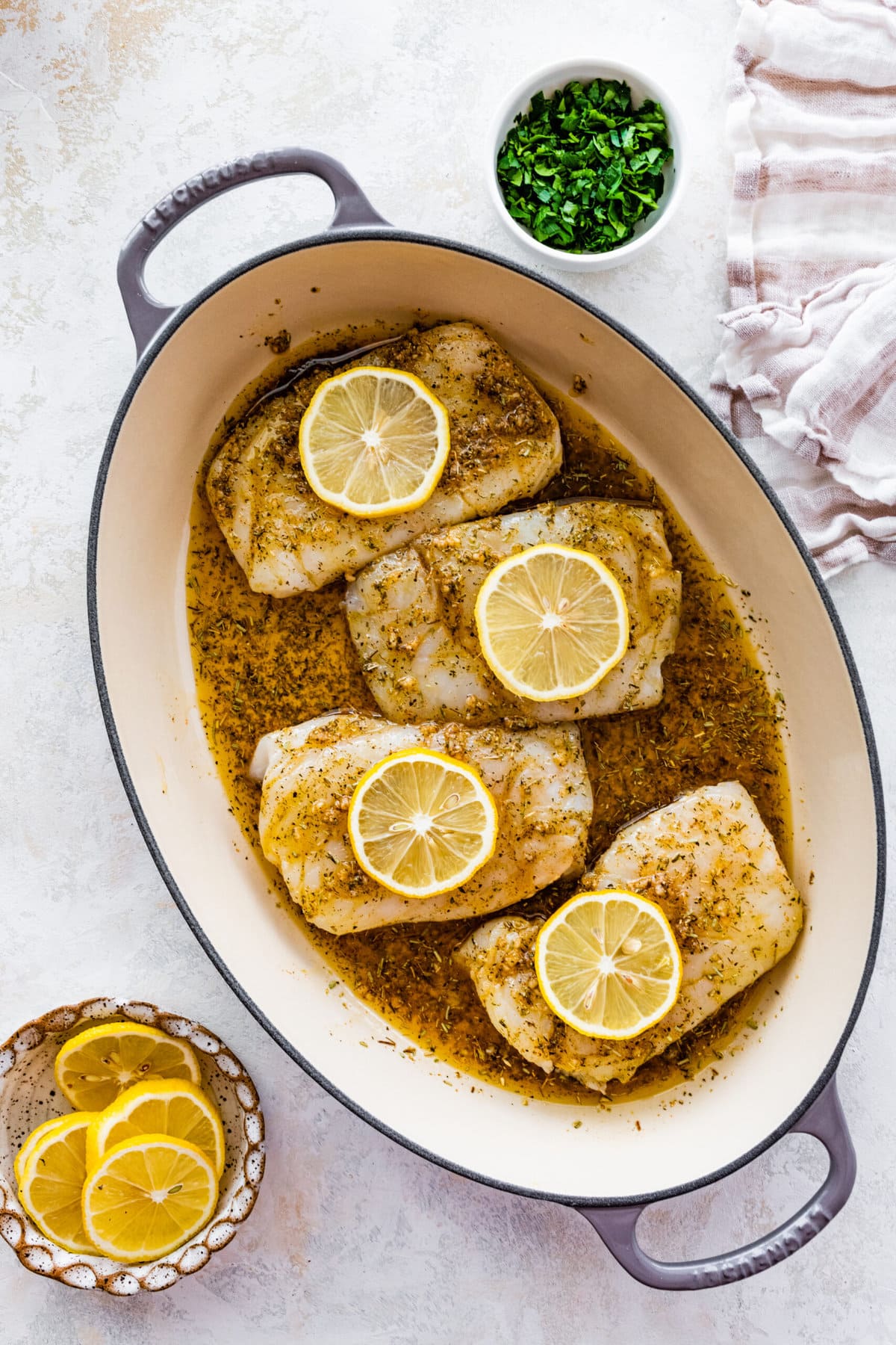 How to make easy oven baked cod step-by-step instructions: place lemons on top of the cod.