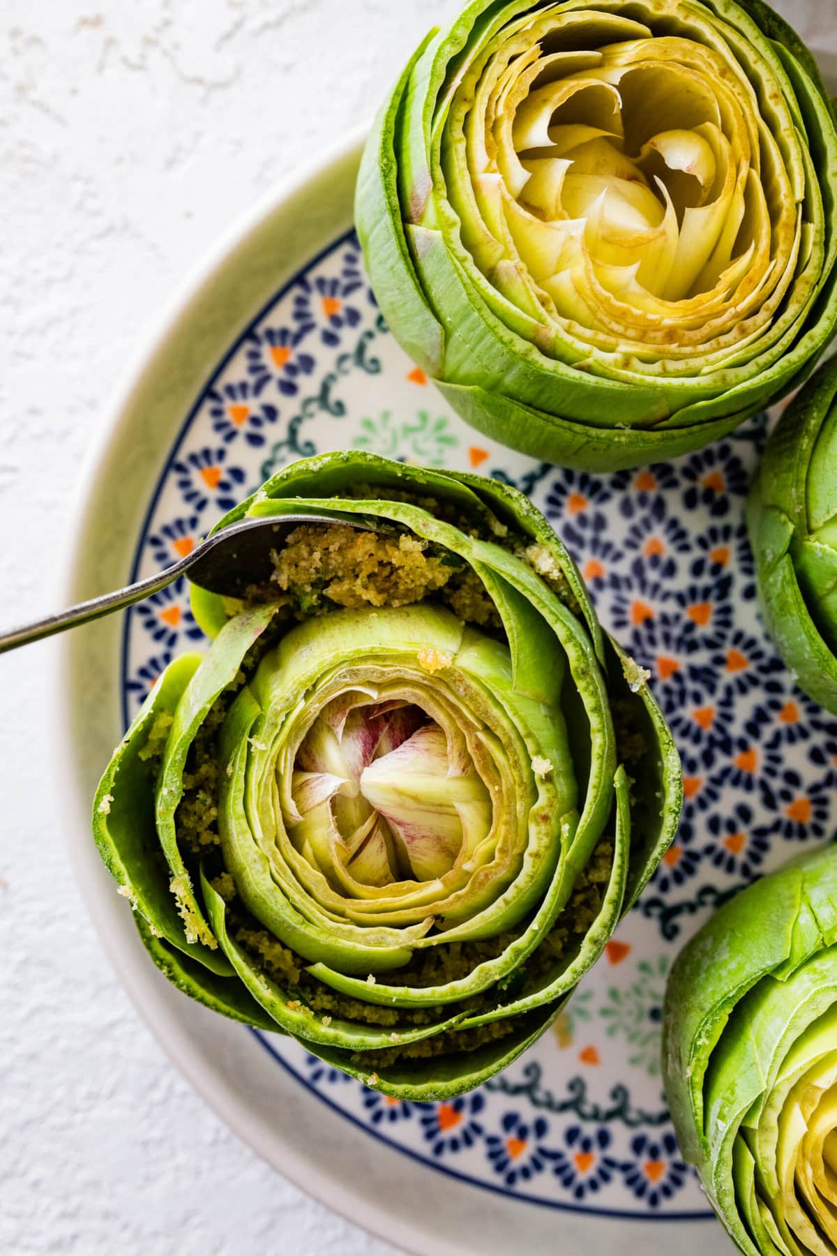 how to make stuffed artichokes step-by-step photos- filling the artichokes with the crumb filling.