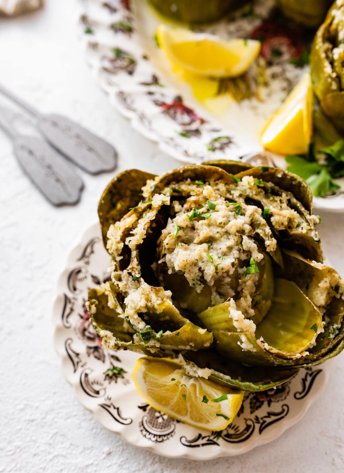 eating a piece of the artichoke with the filling in it.