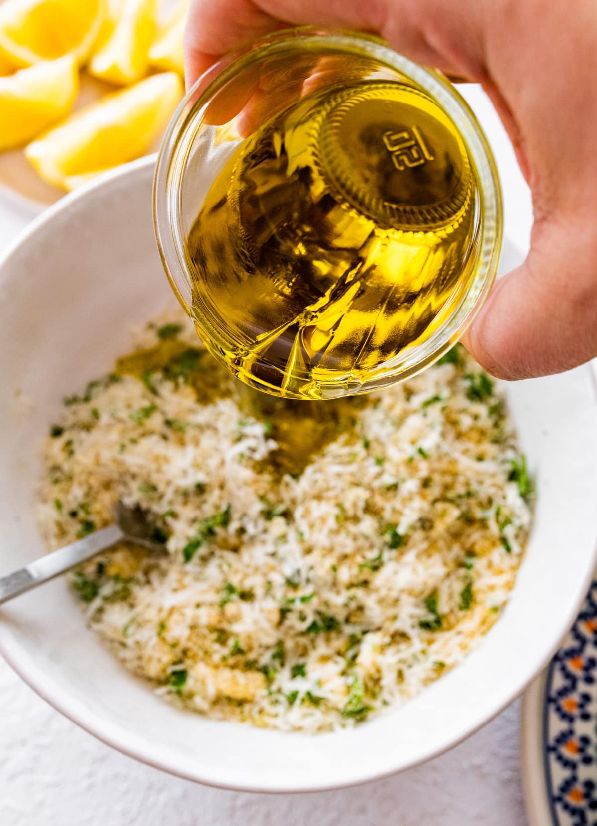 how to make stuffed artichokes step-by-step photos- adding olive oil to the filling of the artichoke.