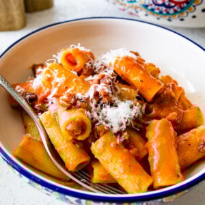 bowl of pasta alla zozzona recipe with the big serving Italian-style bowl of pasta in the background.