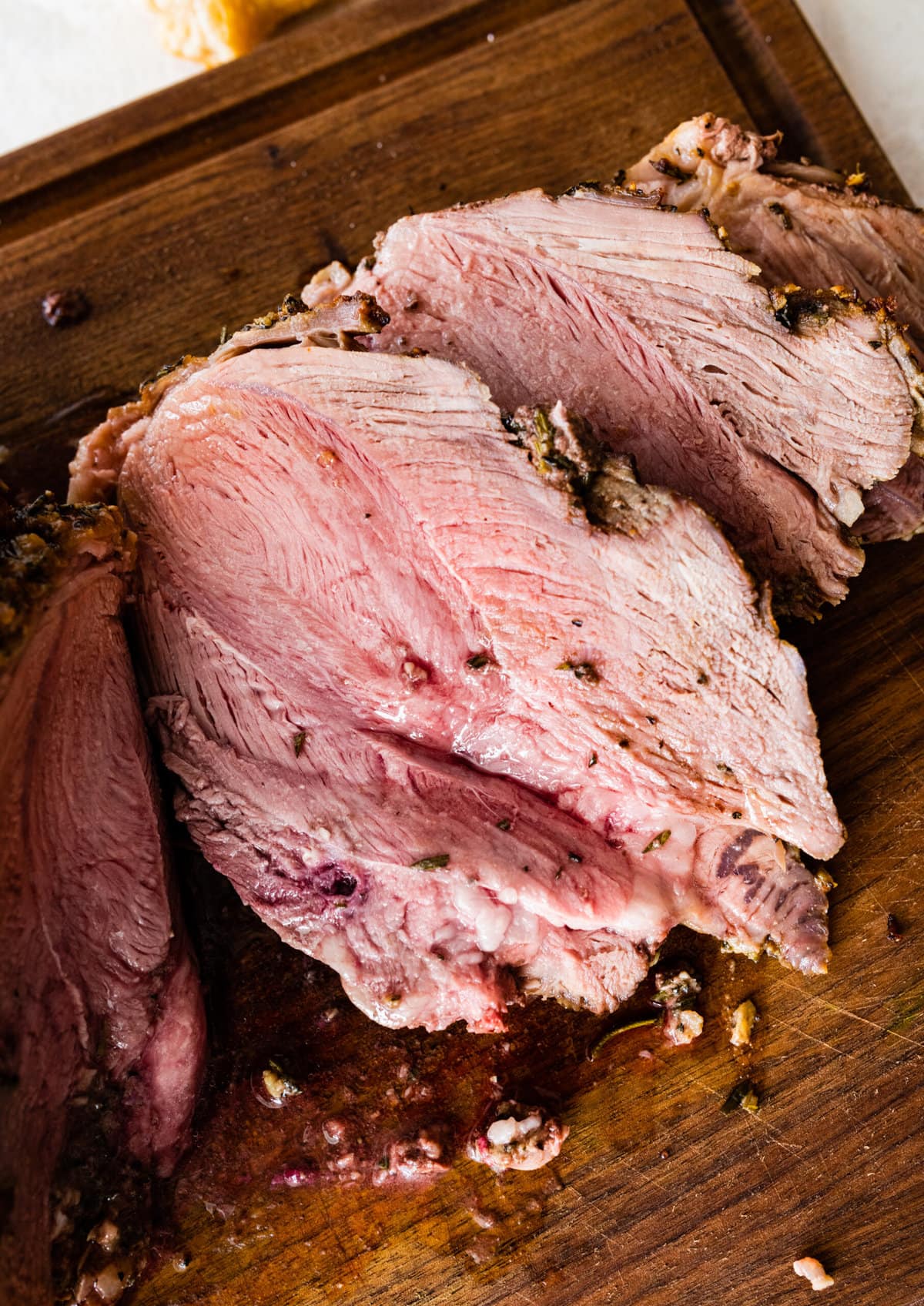 pieces of cut meat on a cutting board. The perfect roast leg of lamb is roasted to perfection.