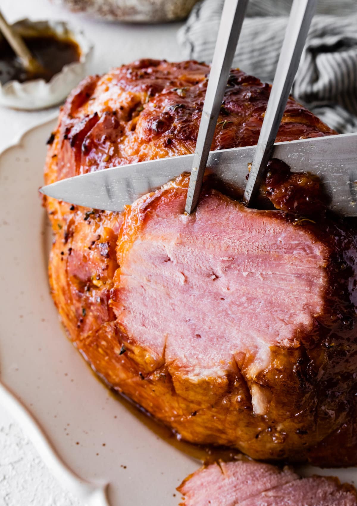 Perfectly baked ham with brown sugar glaze. Cutting the ham in slices with a sharp knife.