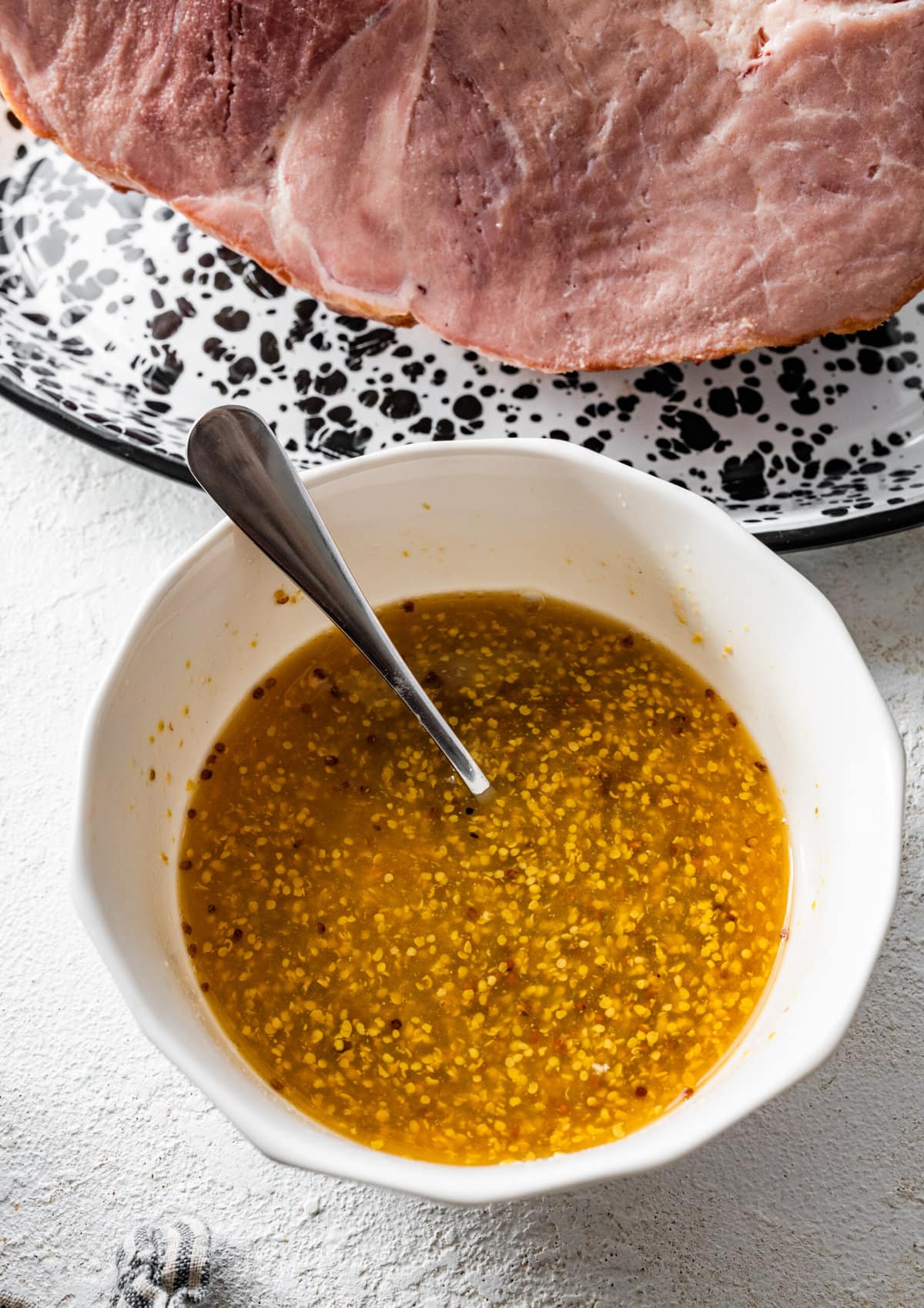 How to make baked ham with brown sugar glaze step-by-step: mixing the orange juice and mustard in a bowl.