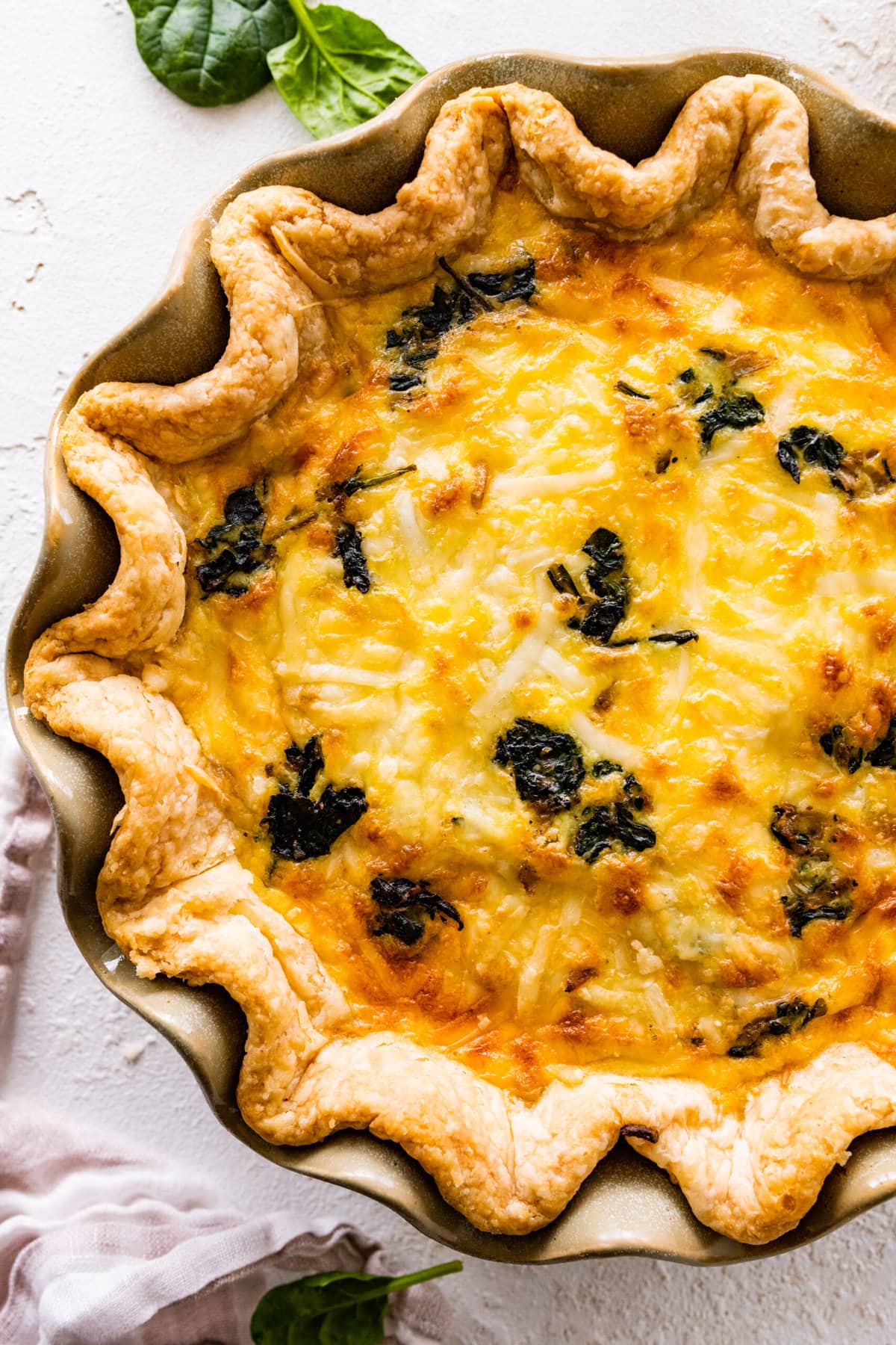 baked spinach quiche recipe out of the oven with golden brown top.