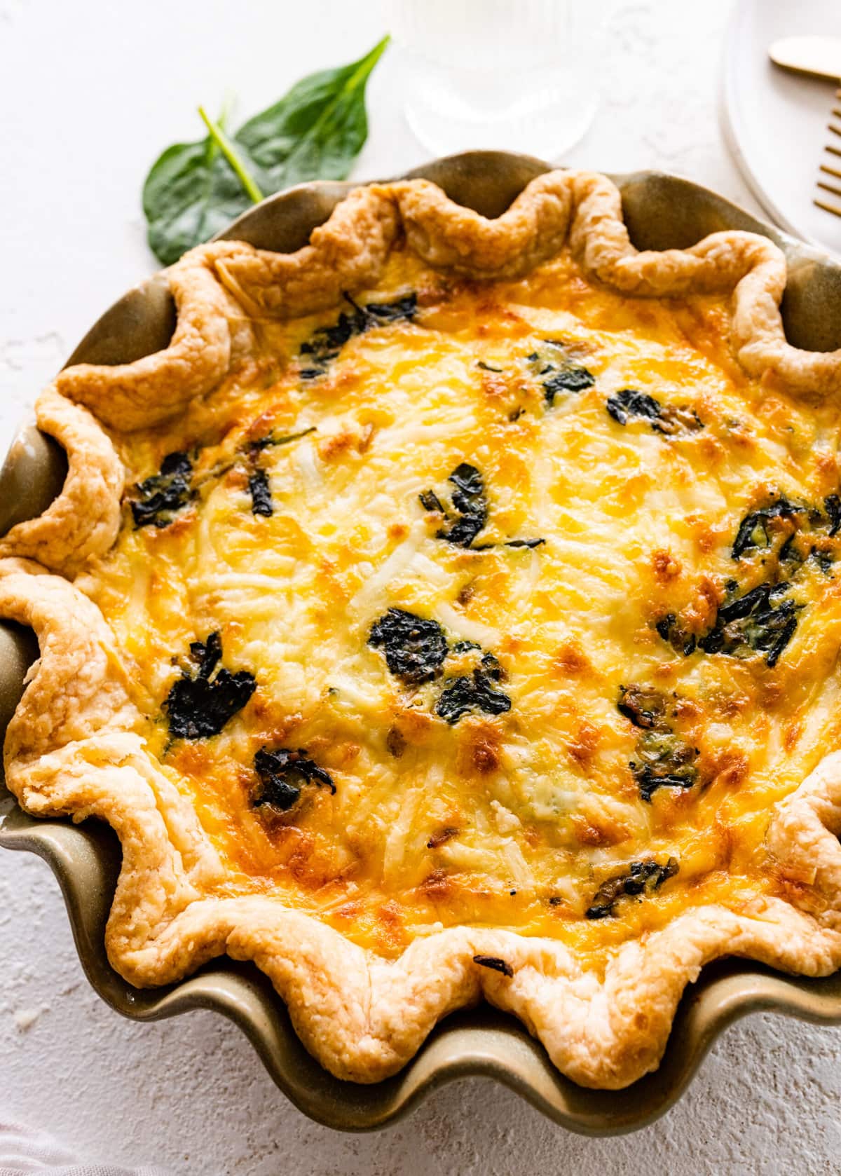 baked spinach quiche recipe out of the oven with golden brown top.