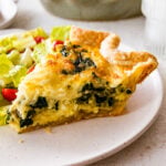 spinach quiche slice on a plate ready to eat.