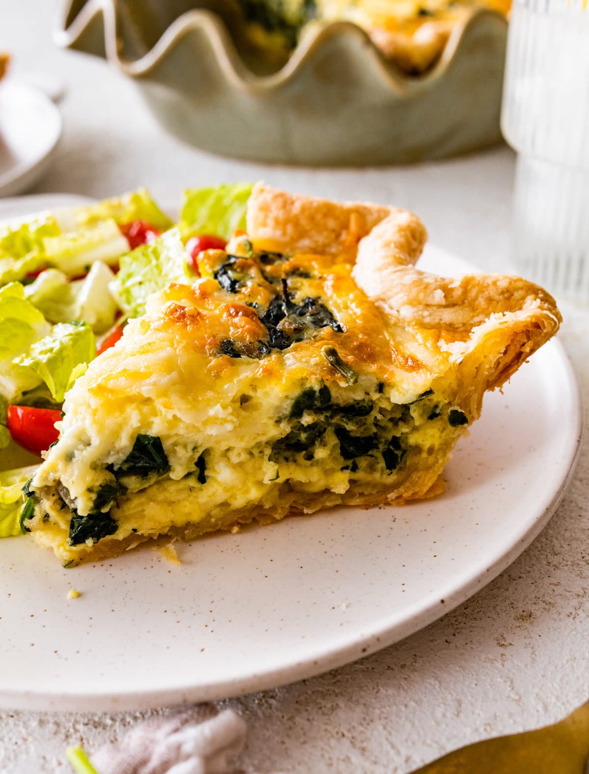 spinach quiche slice on a plate ready to eat.