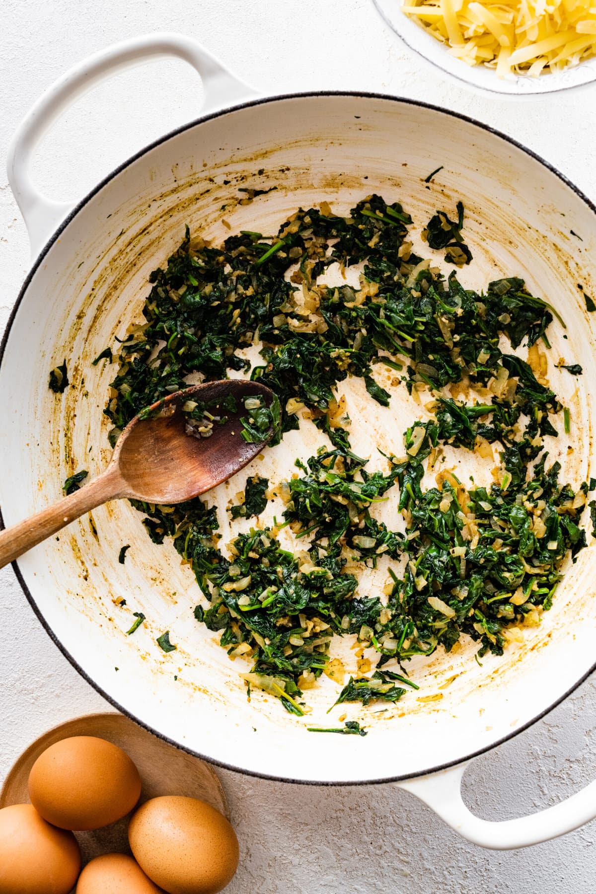 How to make spinach quiche step-by-step: cook spinach until wilted.