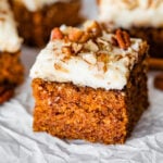 Slices of carrot cake topped with nuts.