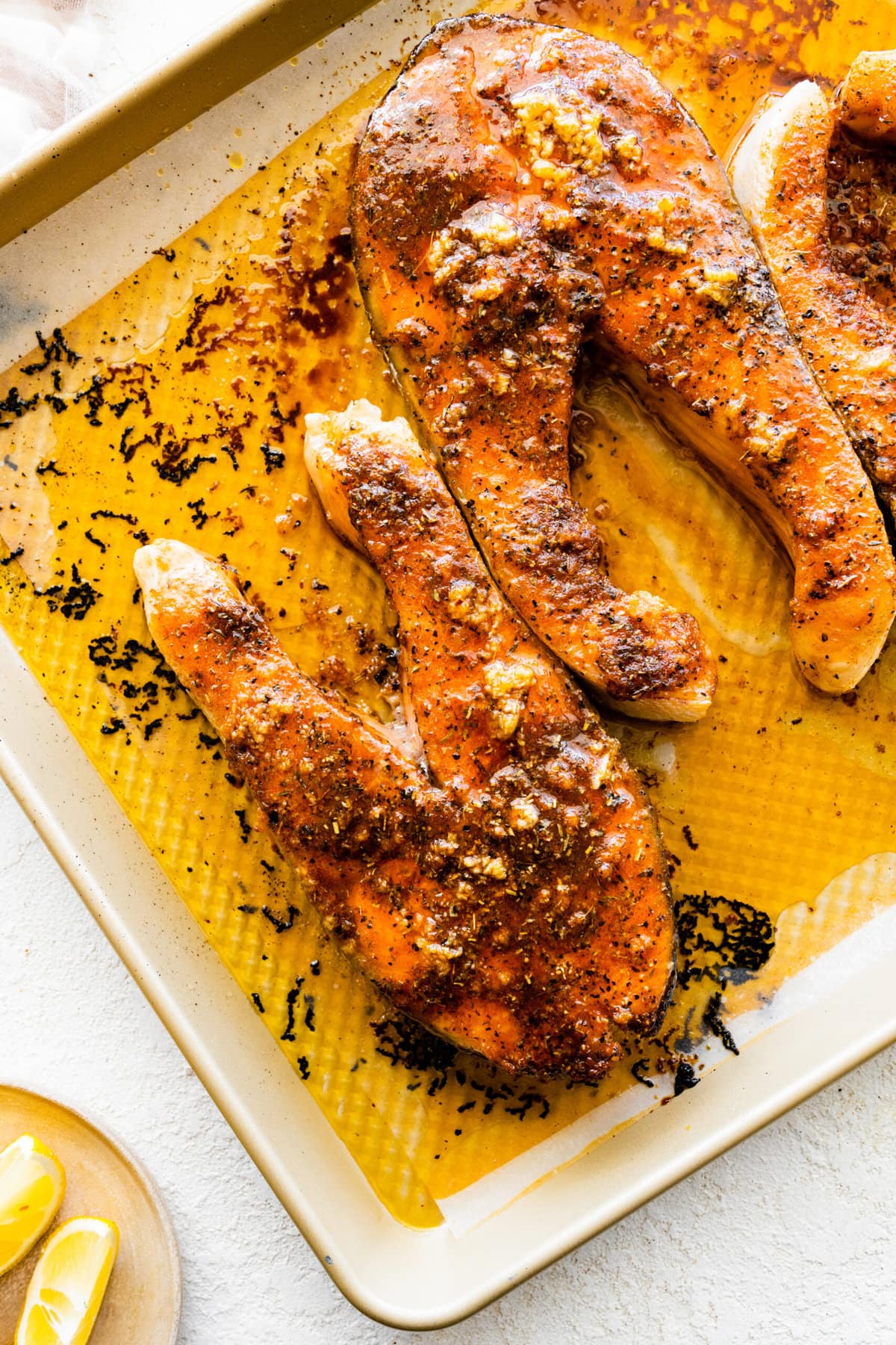 baked salmon steaks on a baking sheet with a nice sear on the top.