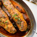 perfectly cooked pork tenderloin in baking pan with juices.