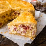 Slice of pizza rustica next to the rest of the Italian Easter pie.