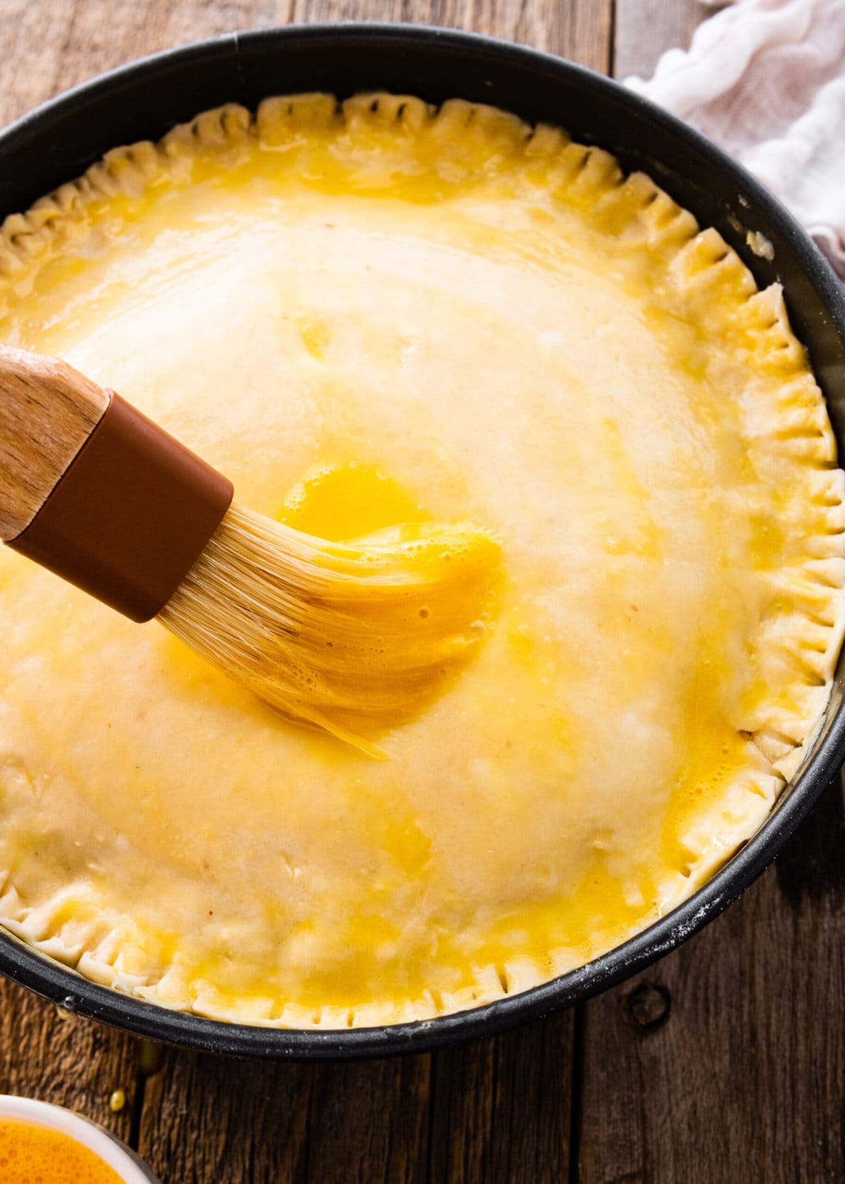 How to make authentic pizza rustica step-by-step: add egg wash to the pie crust.