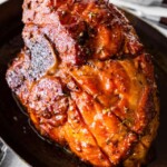 Perfectly baked ham with brown sugar glaze in a large baking dish.