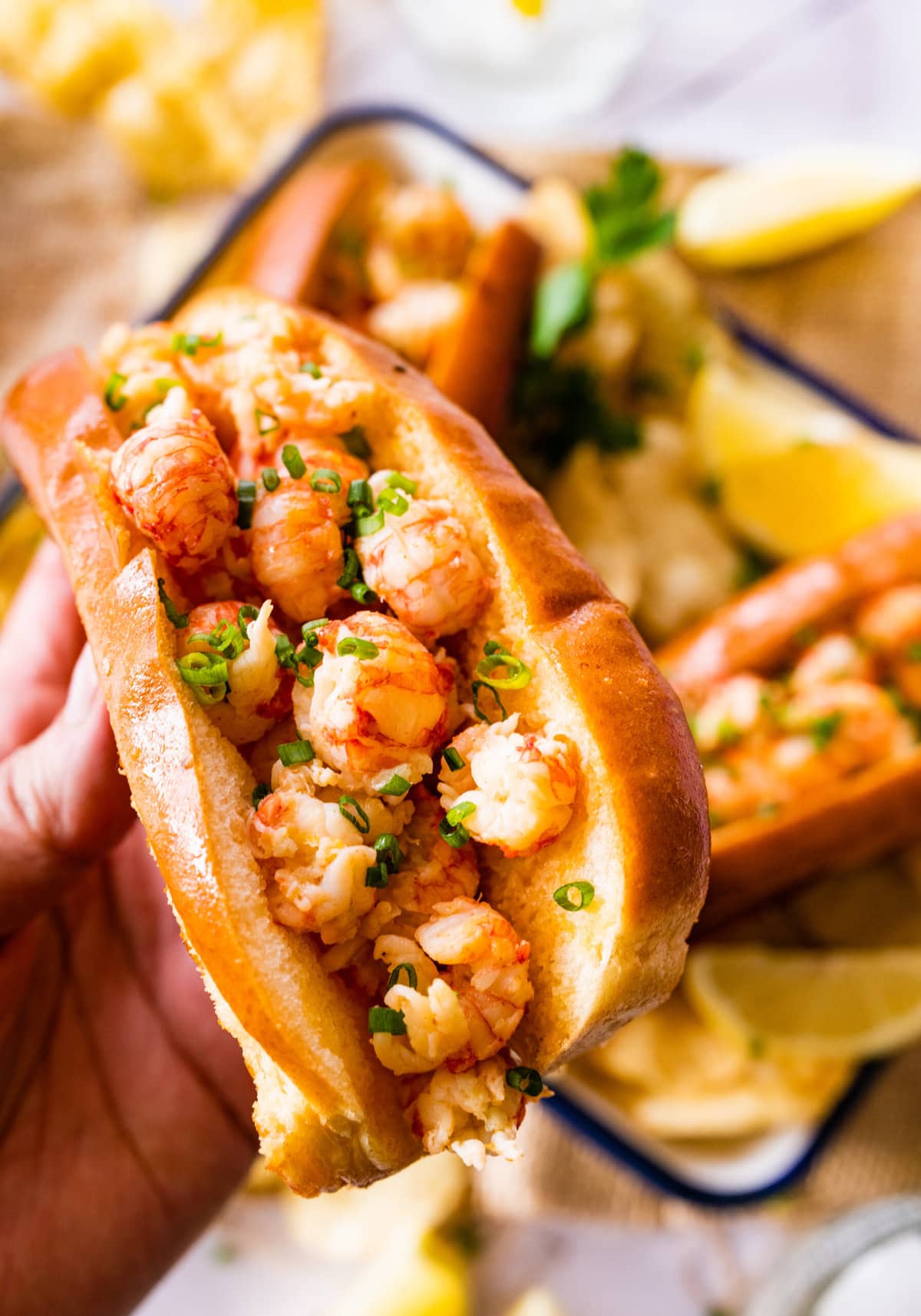 holding the langostino lobster roll ready to eat.