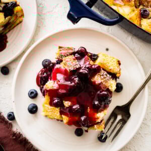 Fork on a plate with a slice of blueberry French toast casserole.