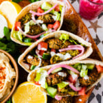 plate of falafel pitas with all the condiments in the pita. Plus a bowl of hummus and extra sauce.