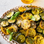 Easy Oven Roasted Zucchini and Yellow Squash Recipe on a platter with basil on the top.