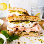 Assembled Mortadella Sandwich with Pistachio Pesto and Burrata with pesto on the side.