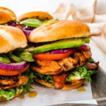Ultimate grilled chicken sandwiches on a tray with parchment paper. Mouthwatering!