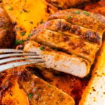 Pork chops cut into slices super juicy. Fork piercing on piece ready to eat.