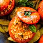BEST Stuffed Tomatoes with Rice (Pomodori Con Riso) in a pan showing with the top off and the creamy risotto in the tomato.