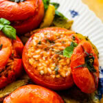 BEST Stuffed Tomatoes with Rice (Pomodori Con Riso) in a pan showing with the top off and the creamy risotto in the tomato.