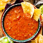 Tortilla chips in a bowl of copycat Chipotle hot salsa.