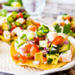 fresh and easy shrimp ceviche on top of tostadas on a white platter. Limes on the side.