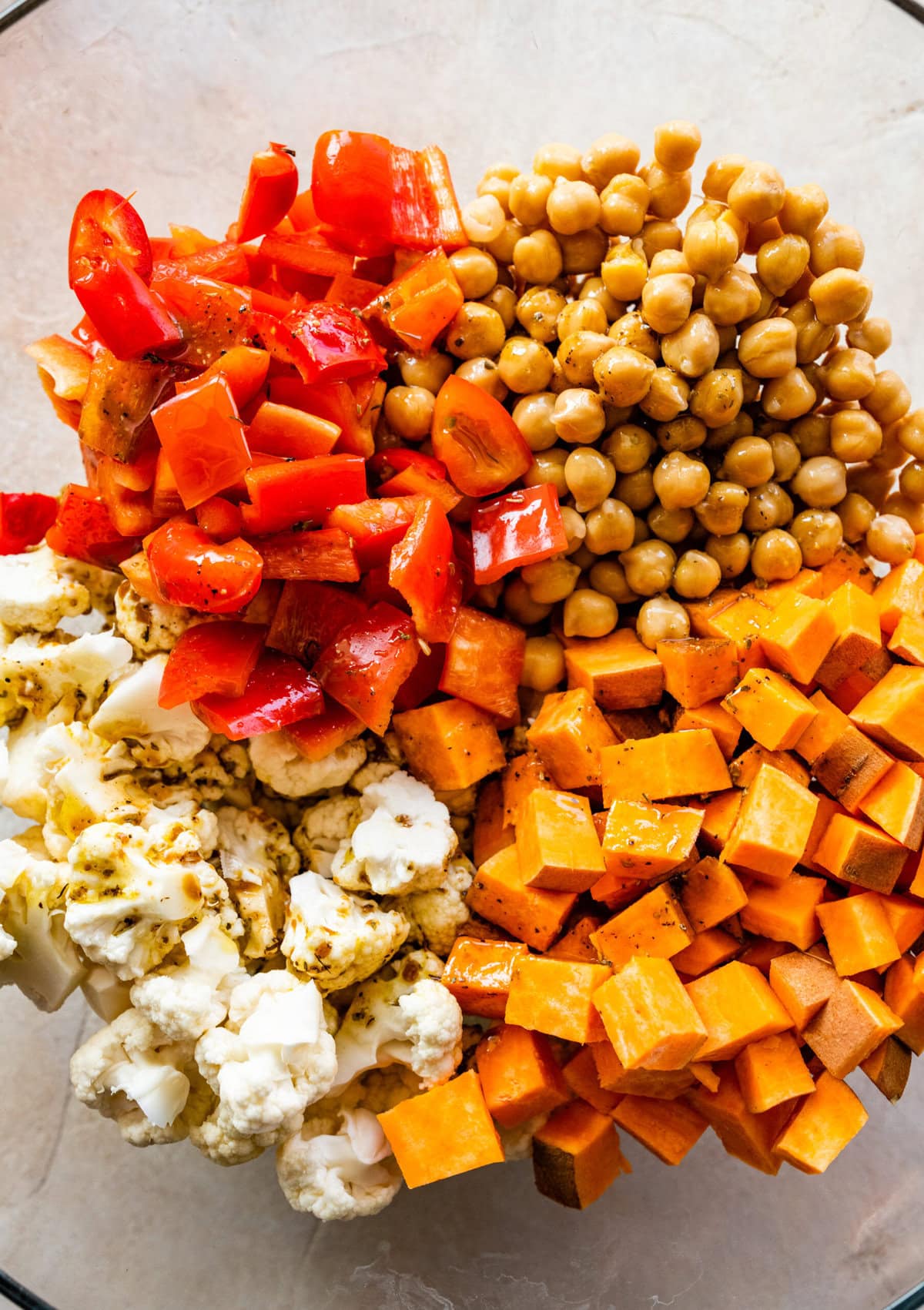 How to make Roasted Veggie Grain Bowls- add all the ingredients to a large mixing bowl.