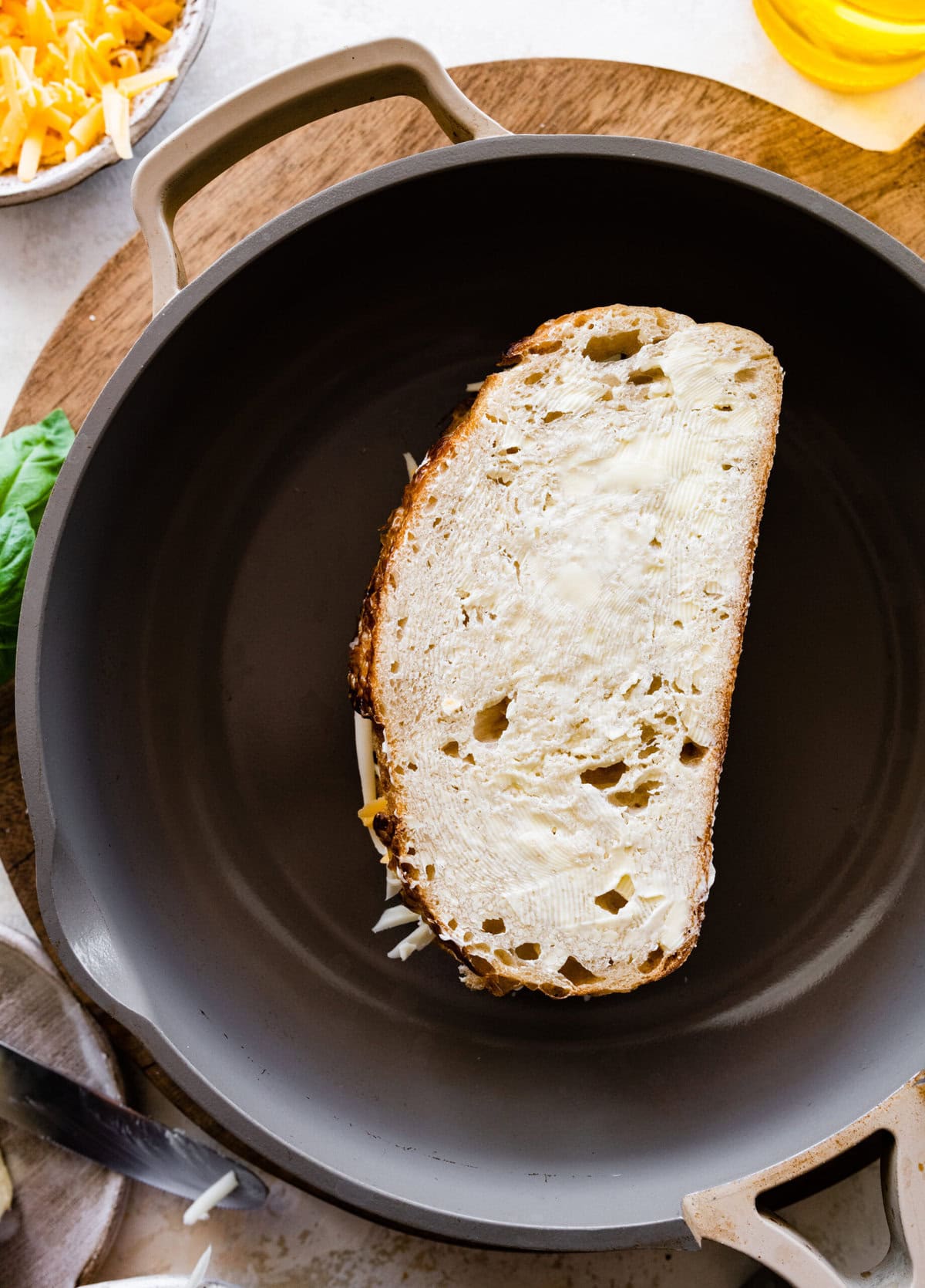 Buttered bread with cheese in a pan.