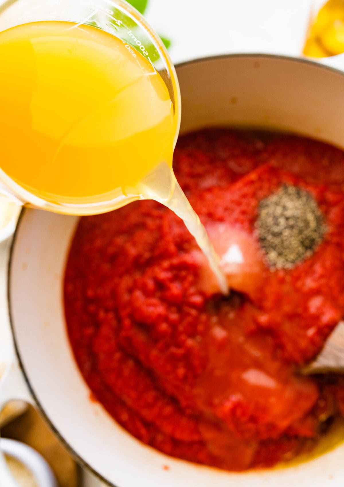 How to make creamy tomato soup with grilled cheese sandwich recipe- add the broth and seasonings to the pan and cook.