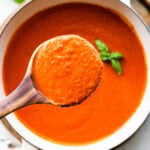 wooden spoon showing a ladle full of the soup.