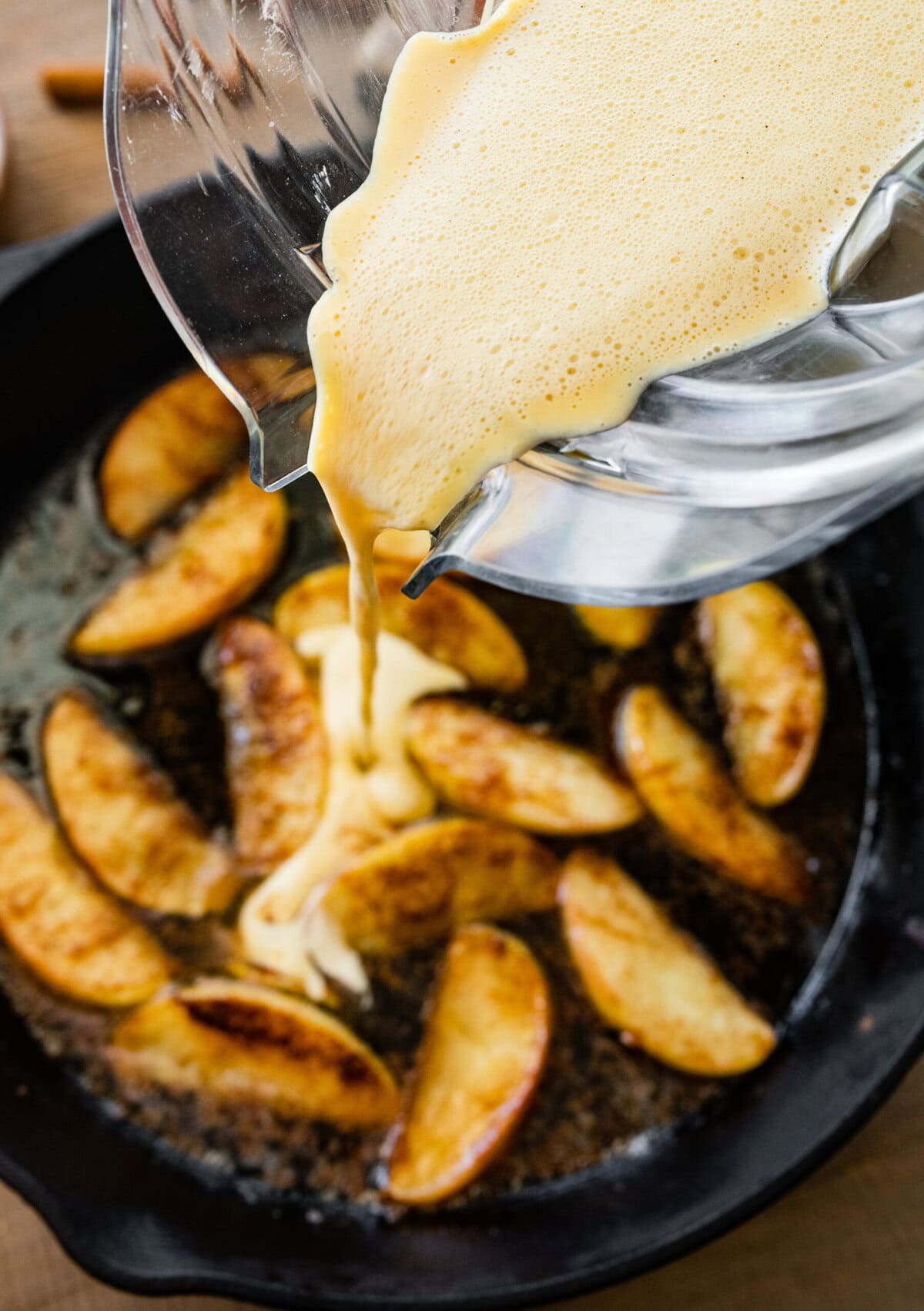 How to make German Apple Pancake- adding the batter to the hot pan with apples.