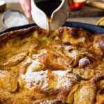 Pouring syrup over the german apple pancake.
