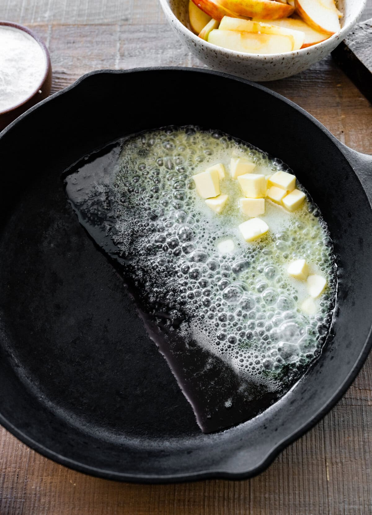 How to make German Apple Pancake- adding the butter to the cast iron pan.