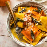 Fork in a bowl of pumpkin Ravioli with Sage Brown Butter Sauce.