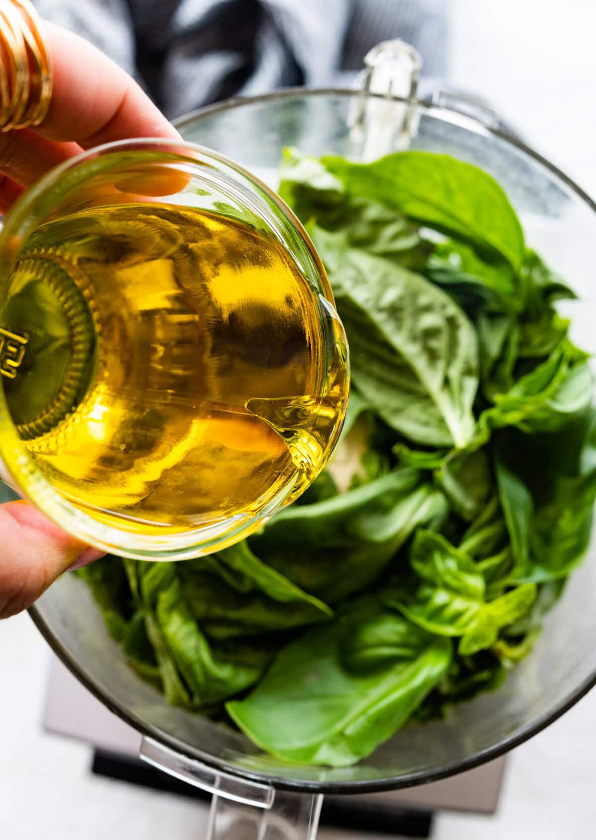 add the olive oil to the basil in the blender.