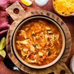Easy Mexican chicken soup in a large serving bowl with toppings all around it.