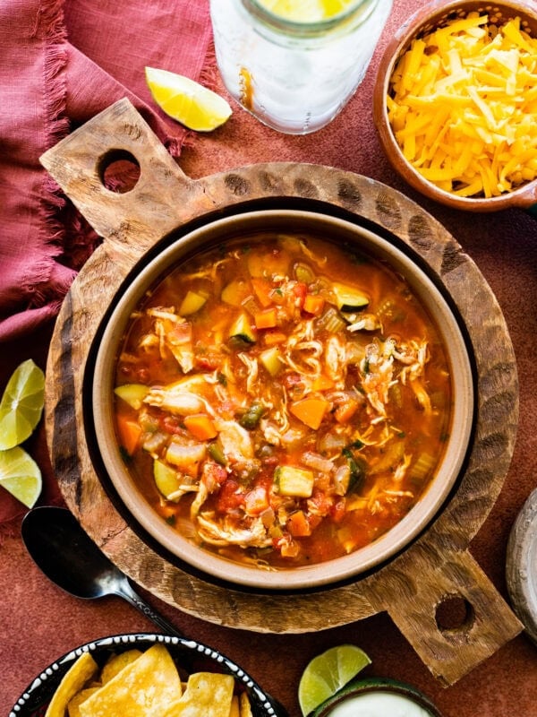 Easy Mexican chicken soup in a large serving bowl with toppings all around it.