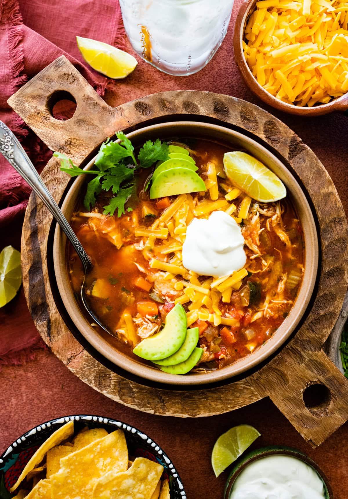 Easy Mexican chicken soup in a bowl with all the toppings on it and a spoon in it ready to eat.