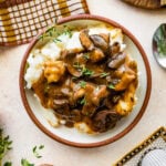Easy mushroom gravy served over mashed potatoes and some herbs over the top.