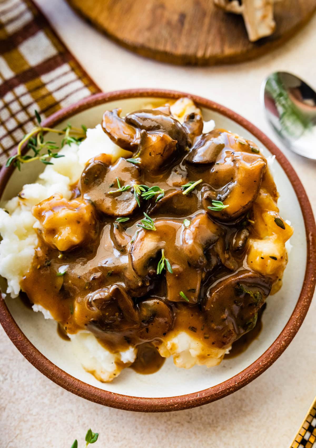 Easy mushroom gravy served over mashed potatoes and some herbs over the top.